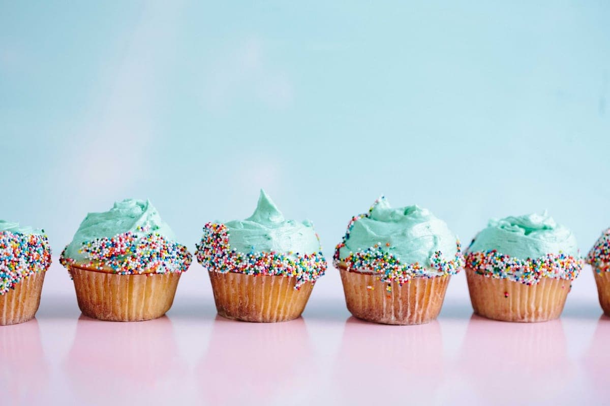 A row of cupcakes with pastel icing and sprinkles